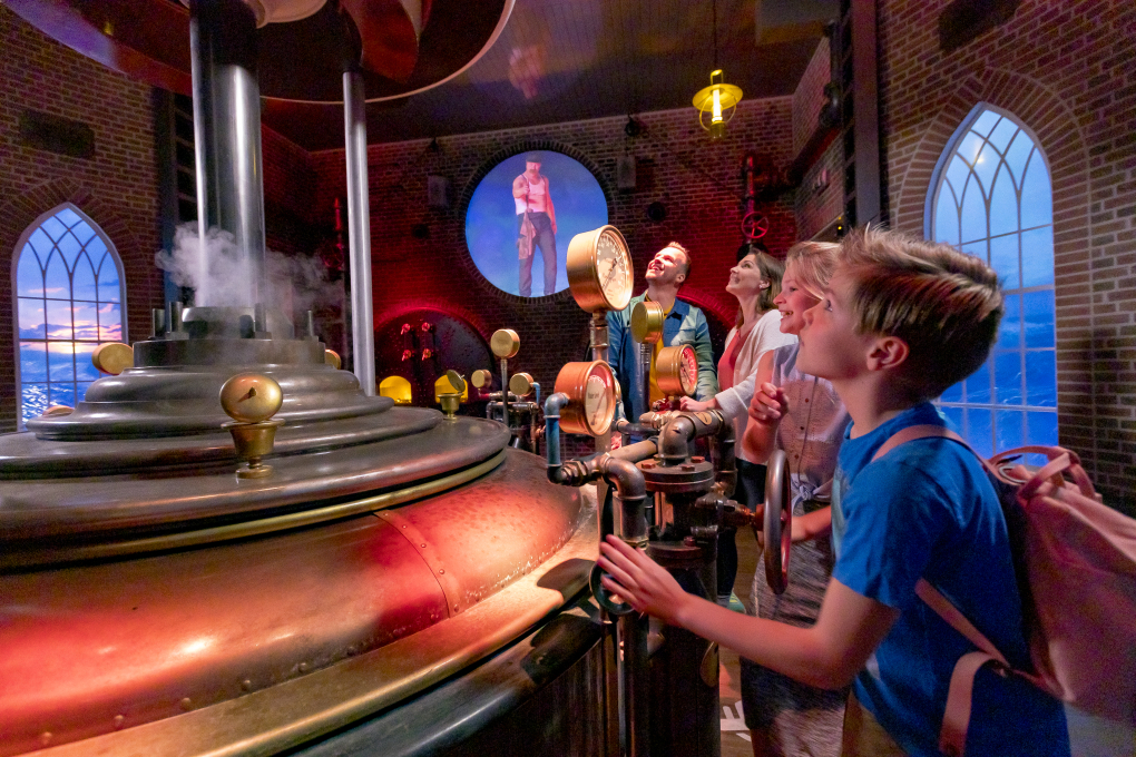 Kinderen bedienen de raders van de stoommachine in attractie De Waterwolf