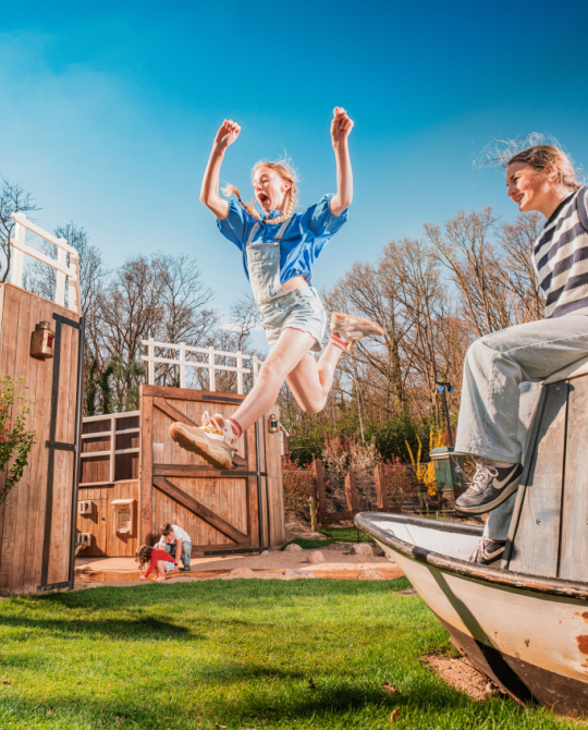 Zomers dagje uit in Madurodam: kinderen klimmen en klauteren in Rivierenland, een meisje maakt een grote sprong